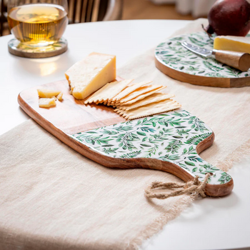 Floral cutting board serving charcuterie and treats.