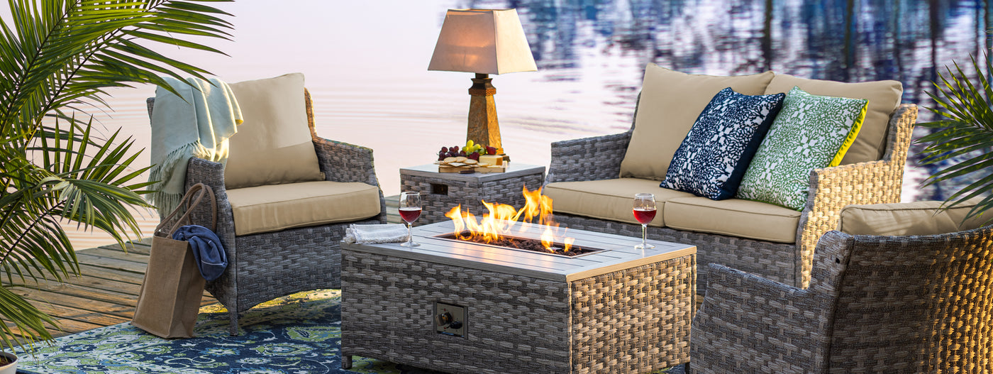 Outdoor patio set with fire pit table by a body of water
