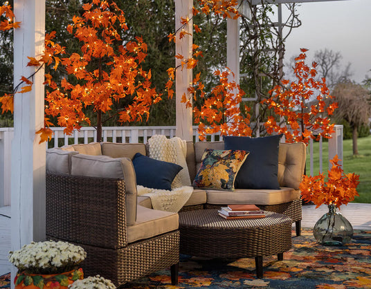Outdoor patio with wicker furniture, colorful cushions, and autumn-themed decor.