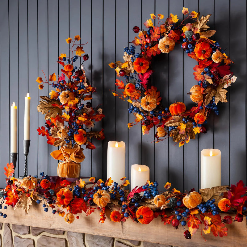 Decorative autumn wreath with pumpkins, berries, and candles on a wooden surface against a dark wooden panel background.