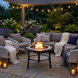 Round fire pit table with black and white mosaic design on a white background