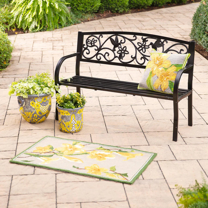 Decorative outdoor bench with floral pillow and matching rug on a patio